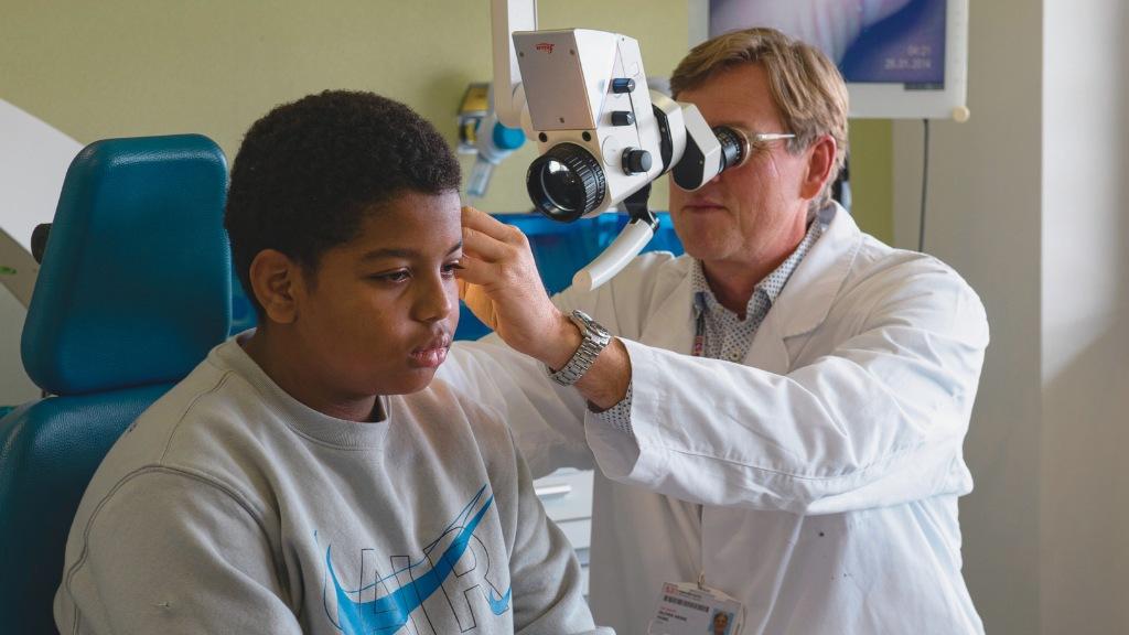 Dr. Oliver Haag examining his patient Aissam