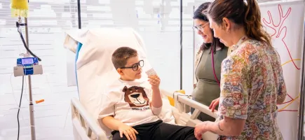A patient participating in a clinical trial with a family member and healthcare staff. A patient participating in a clinical trial with a family member and healthcare staff.