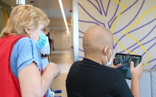 A patient at the Hospital plays Saurus Kids, accompanied by a volunteer from Sant Joan de Déu Barcelona Children's Hospital A patient at the Hospital plays Saurus Kids, accompanied by a volunteer from Sant Joan de Déu Barcelona Children's Hospital