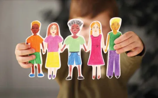 Niño sosteniendo un dibujo con personajes de diferentes etnias. Hospital Sant Joan de Déu Barcelona Niño sosteniendo un dibujo con personajes de diferentes etnias. Hospital Sant Joan de Déu Barcelona