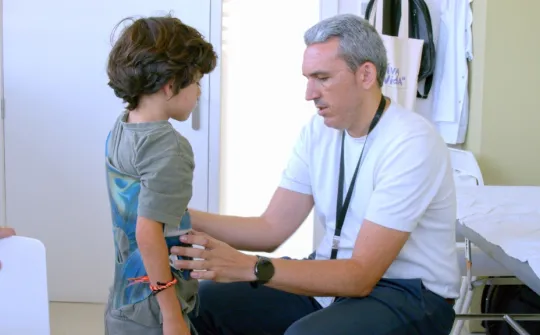Dr. Alejandro Peiró with a paediatric patient wearing a brace Dr. Alejandro Peiró with a paediatric patient wearing a brace