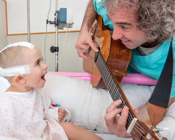 Un paciente recibe al musicoterapeuta en la habitación Un paciente ingresado en un taller de musicoterapia en el Hospital Sant Joan de Déu