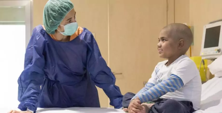 Un niño y una enfermera en una cámara de aislamiento de Trasplante de Progenitores Hematopoyéticos infantil en el Hospital Sant Joan de Déu